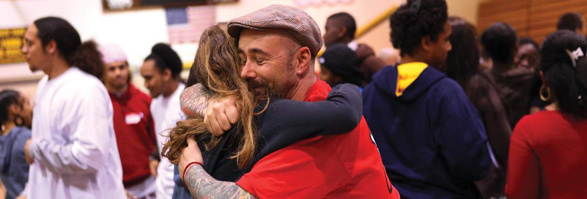 man and woman embracing in crowd of people