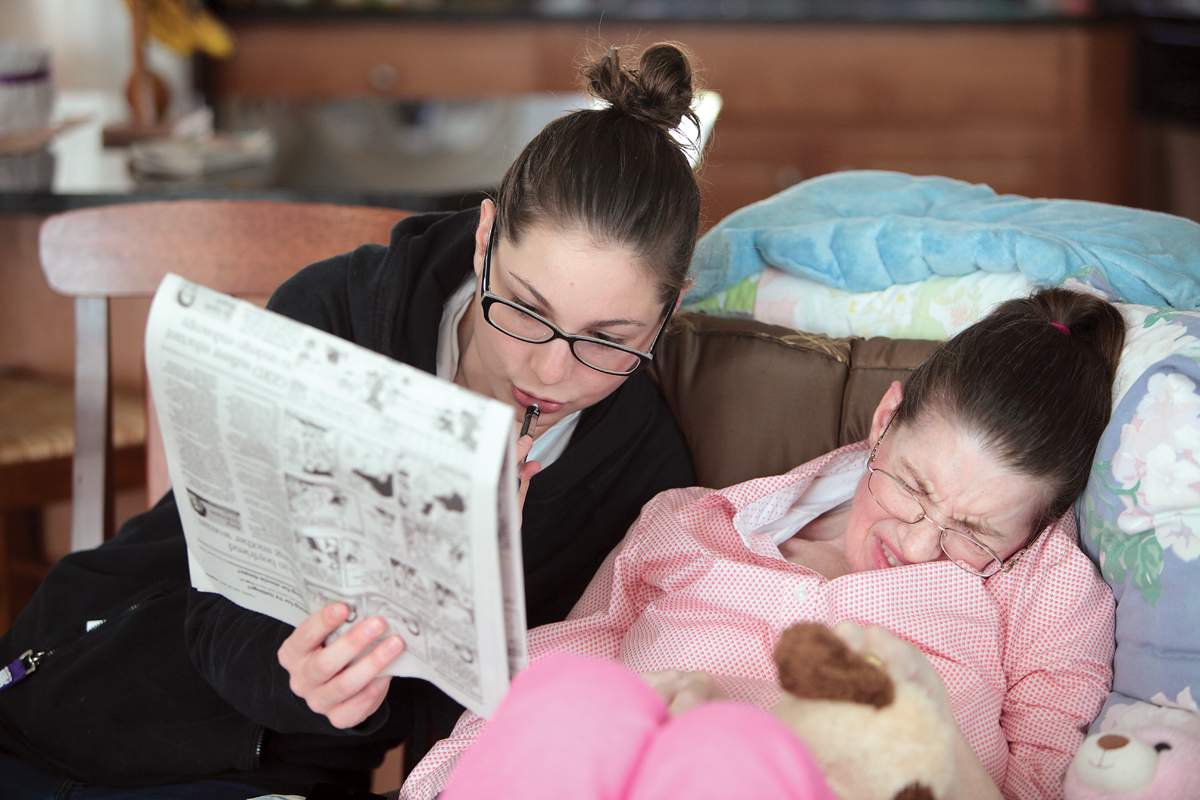 student helps hospice resident with a word puzzle