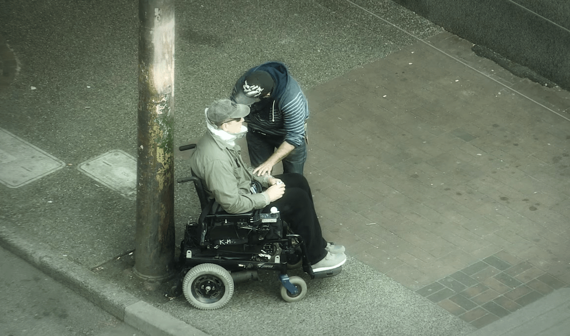 man helping man in wheelchair