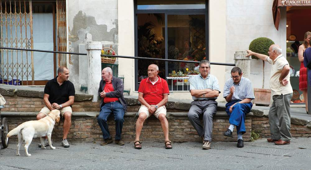 men sitting in a row, hanging out, laughing and talking