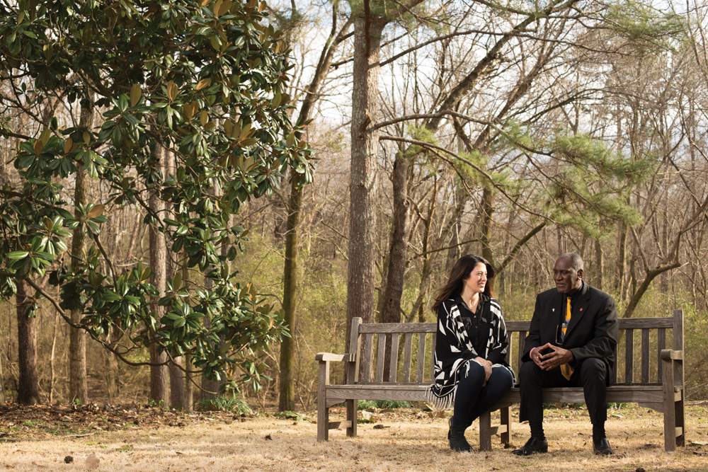 Elizabeth Paine and Don Cole sitting on bench together on fall day