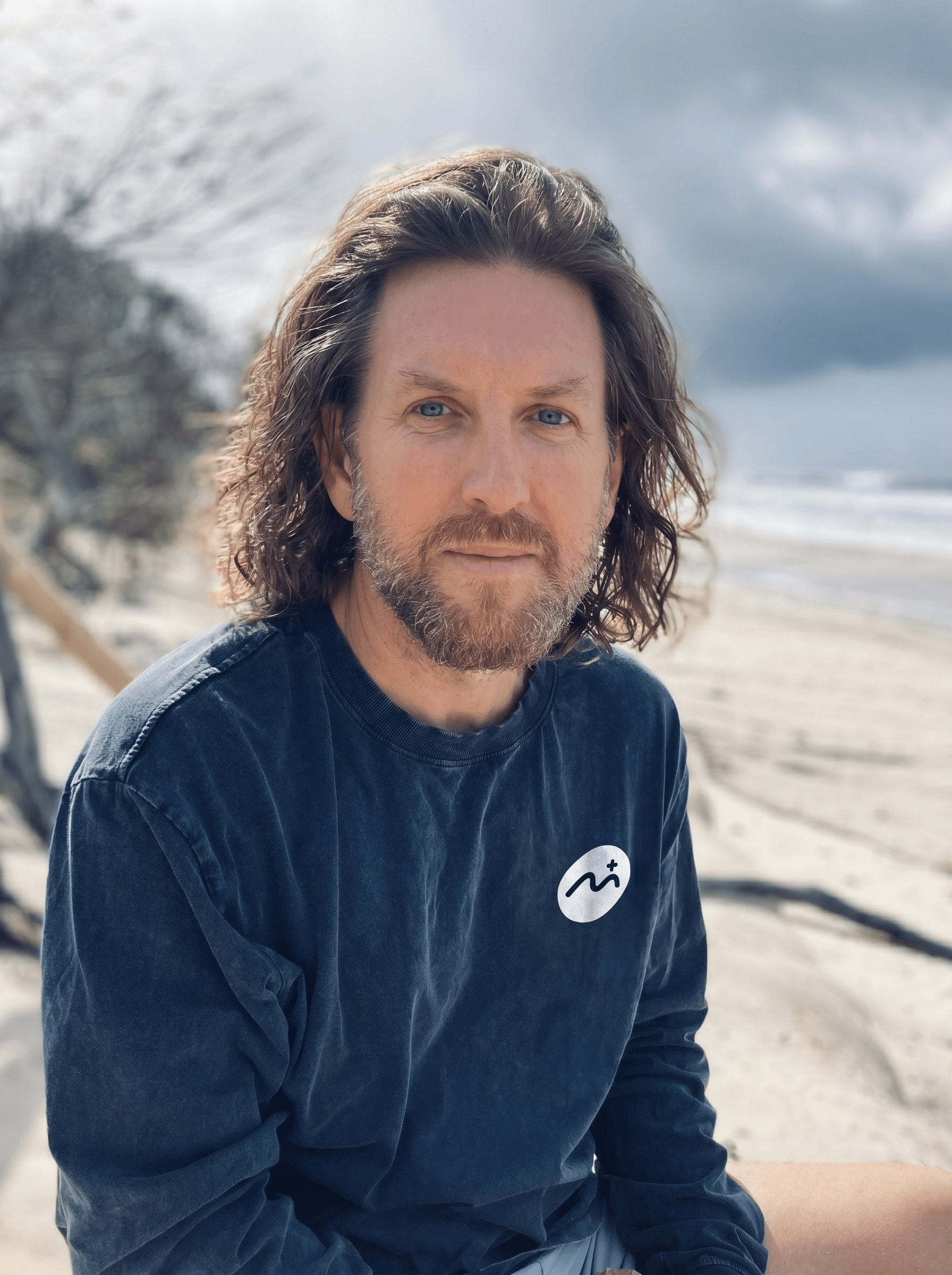 Photo of Joe Russell, new CEO of Mindful.com and Mindful.org, sitting on the beach.