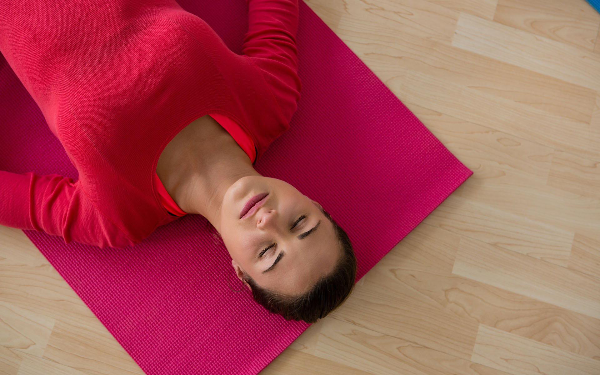A 12-Minute Meditation to Nurture a Felt Sense of Gratitude - Woman on a yoga mat lying down doing a body scan