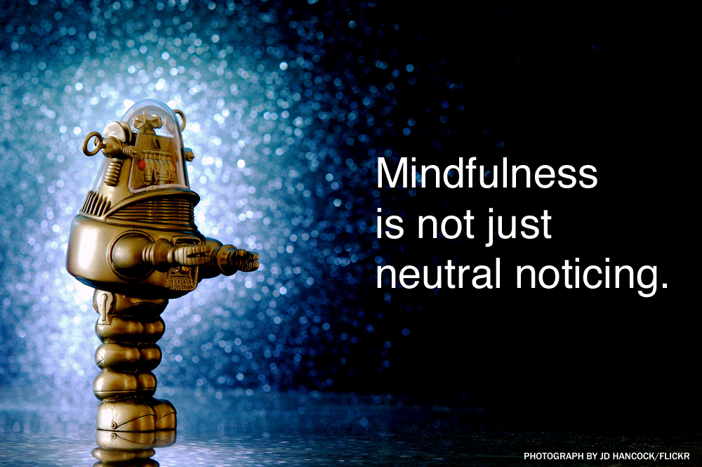 Robot standing next to the phrase: mindfulness is not just neutral noticing