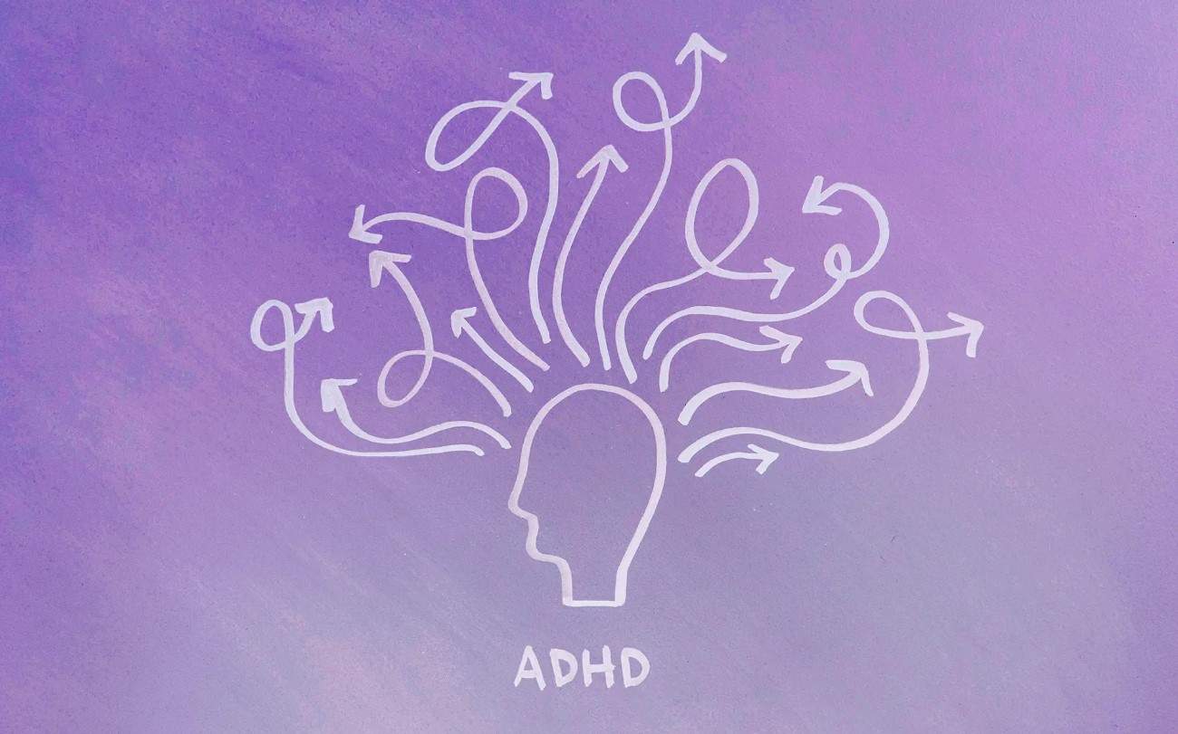 Silhouette of a head with many twirly arrows coming out representing scattered attention with ADHD