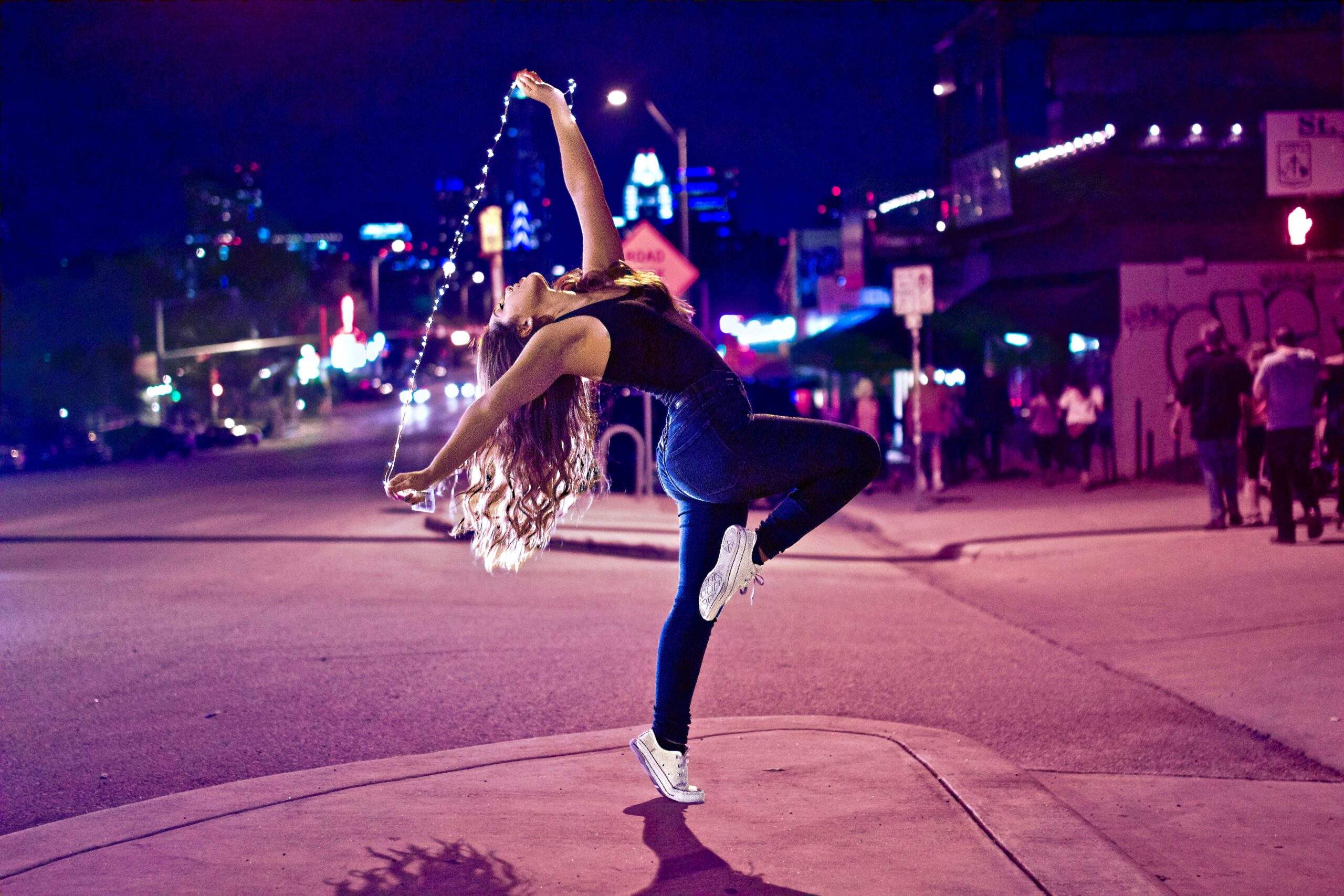 a woman dancing on a city street at night. how to get into the flow state