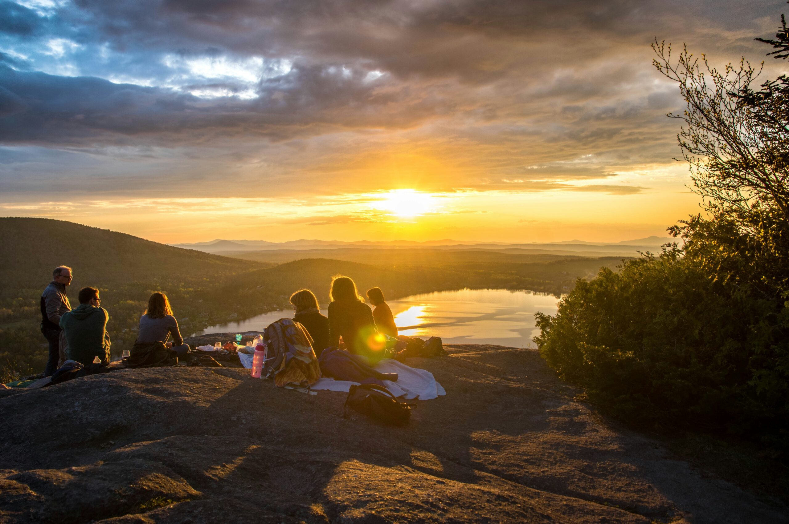 Friends enjoying a sunset at the top of a climb