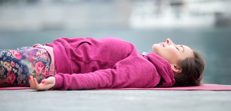 woman lying on yoga mat