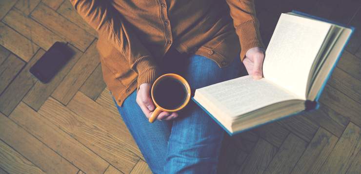 woman reading book with coffee