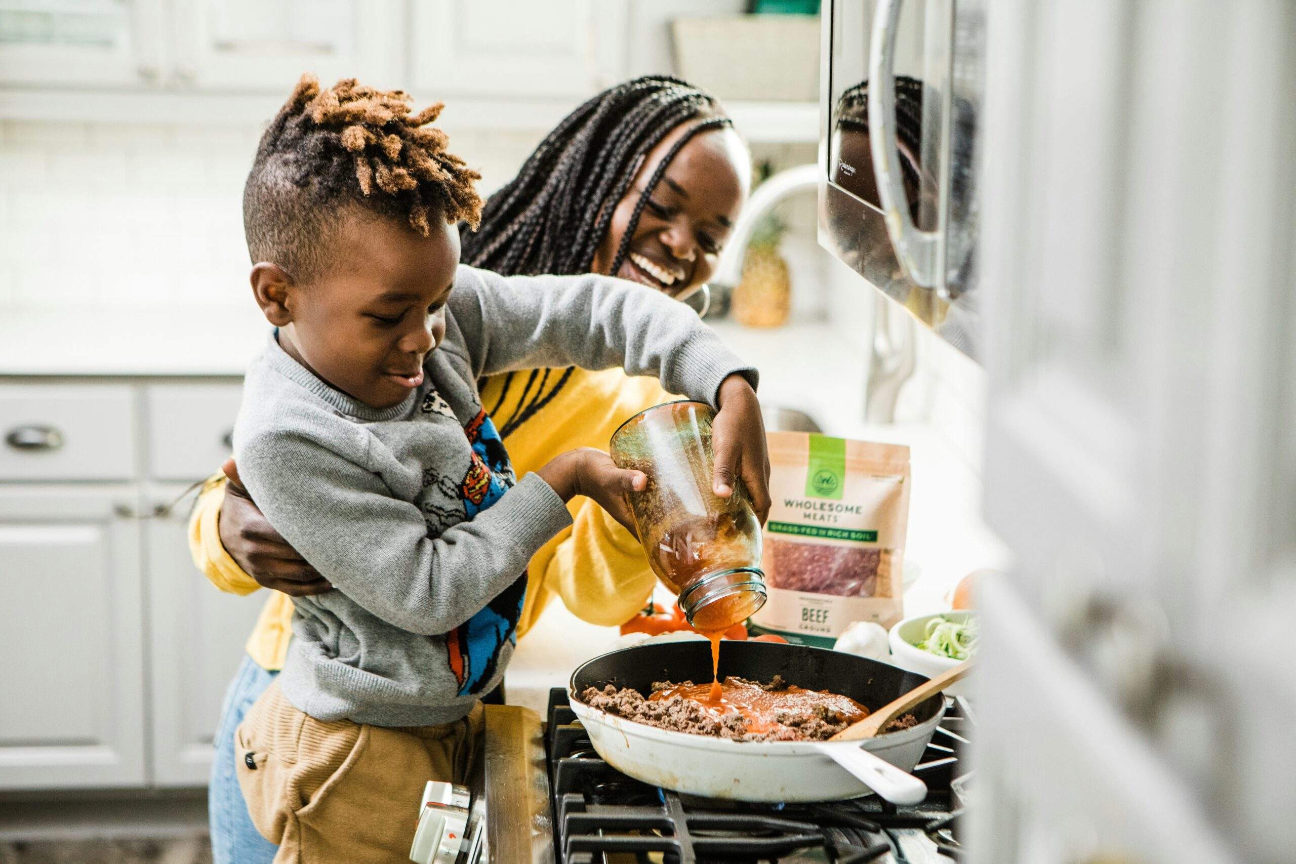 African American mother cooking with her son