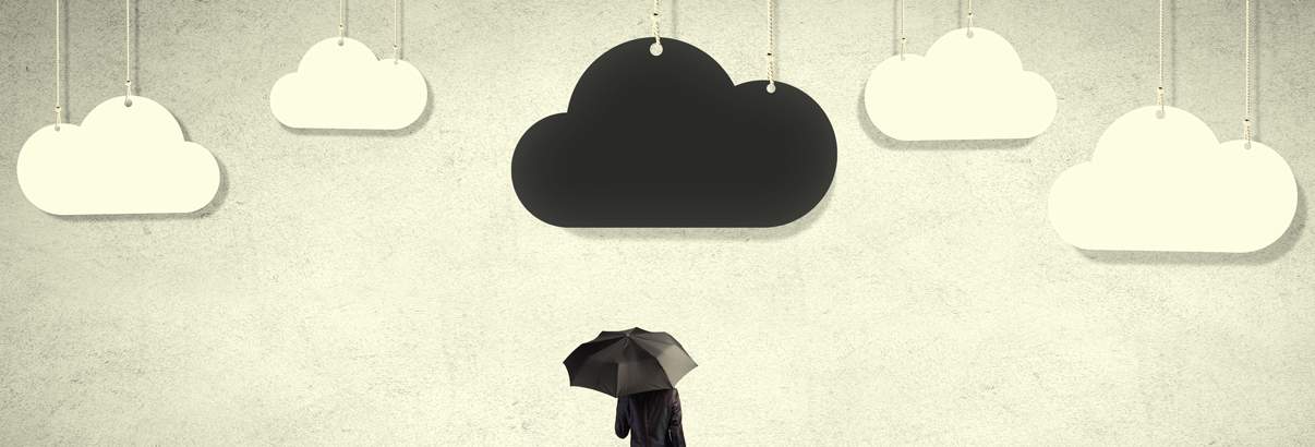 man standing under clouds with umbrella