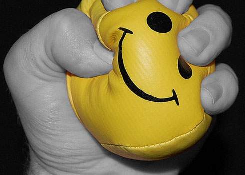 A yellow punching bag with a smiley face on it.
