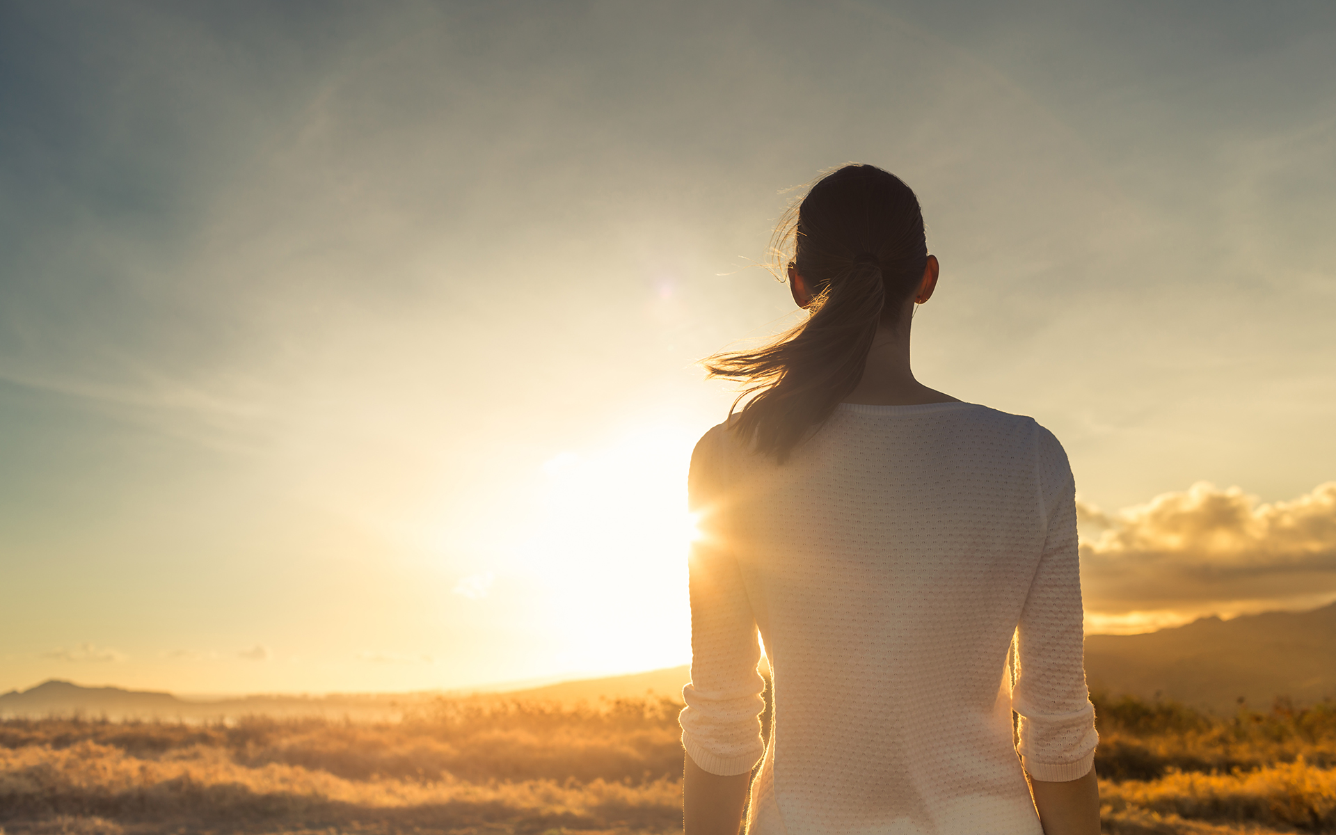How to avoid feeling overwhelmed in stressful times - Woman admiring a sunset