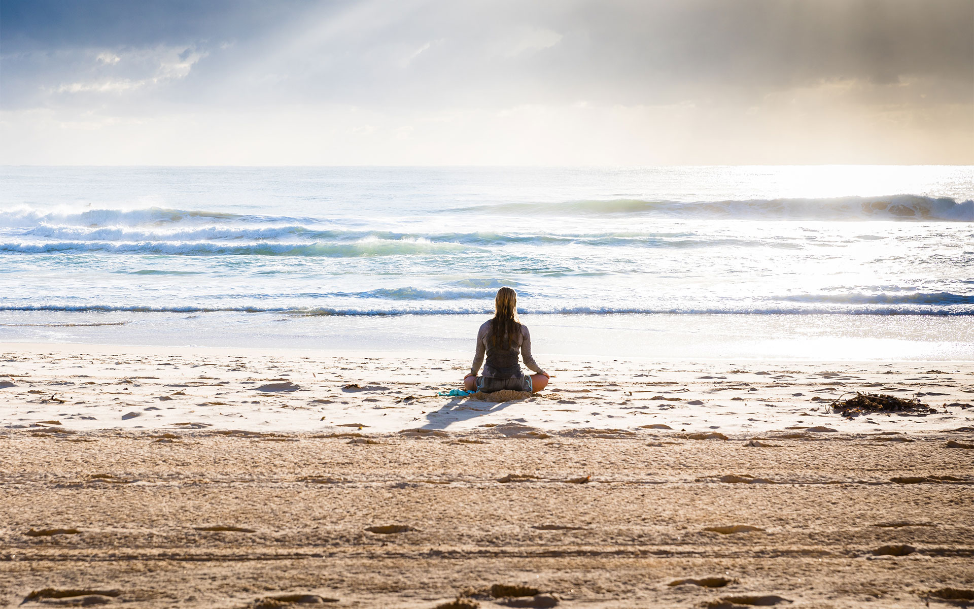 woman meditating on beach. notice the body