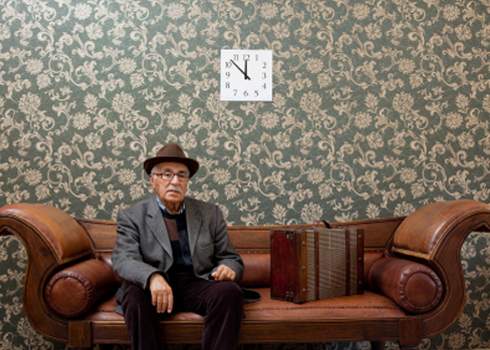 A man sitting on a brown leather couch.