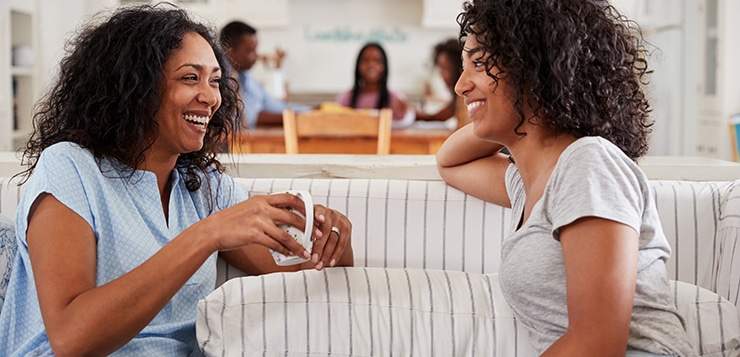 Mother Talking With Teenage Daughter On Sofa