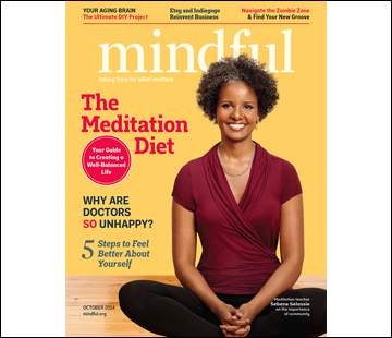 A smiling woman with short curly hair sits cross-legged on the cover of 