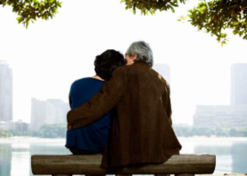 A couple sitting on a bench.