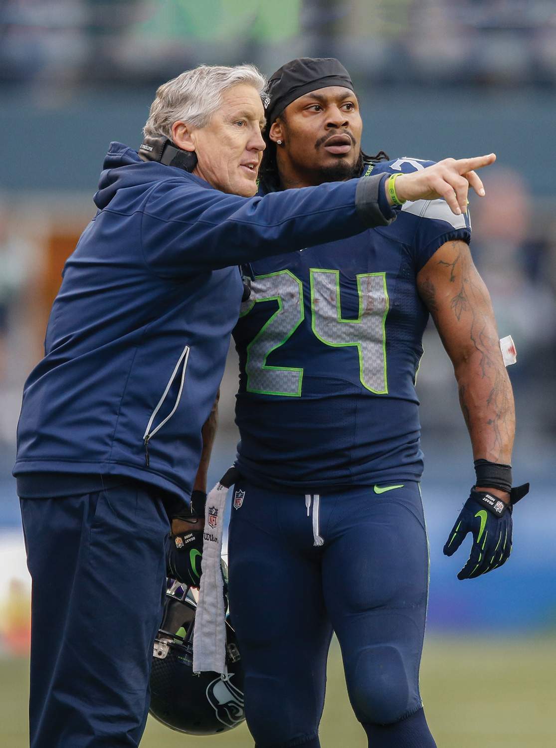 Coach Carroll gives direction to All-Pro running back Marshawn Lynch.