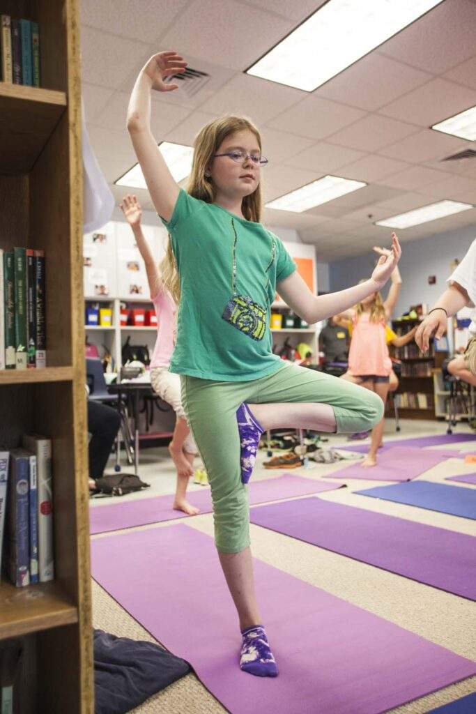 Student Kaylee Weber practices her tree pose. Marian encourages students to "stand tall like a mountain" and to feel their bodies rest like mountains. The movement practice encourages students to connect their minds to their bodies.
