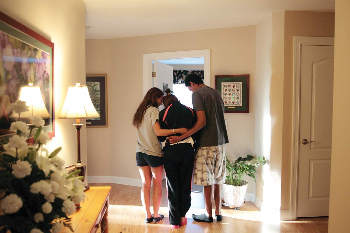 students help hospice resident to her room