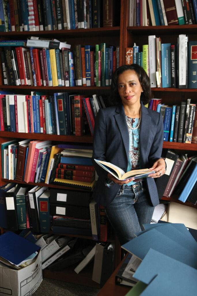 woman standing by bookcase, reading.