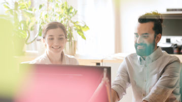 Want to Boost Your Well-Being at Work and Get More Done? Forgive Your Colleagues happy creative team with computer in office