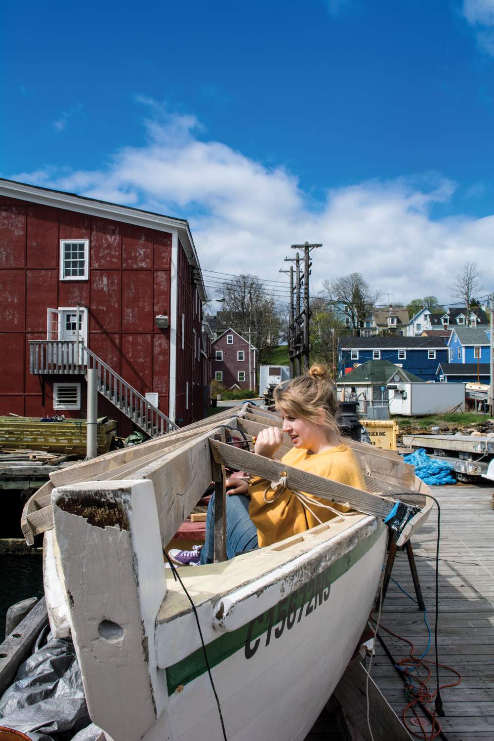 teen works on sailboat