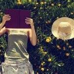 Cultivate a Mindful Attitude with These New Books and Podcasts woman reading in grass