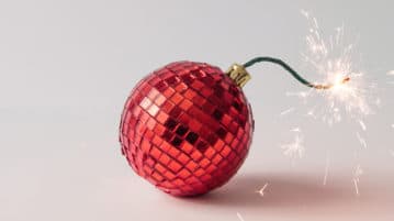 Curb Your Inner Critic Over the Holidays with Self-Compassion christmas tree bulb that looks like a fuse on a bomb