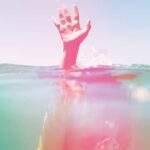 How Creativity Frees the Mind person under water, holding hand above watear