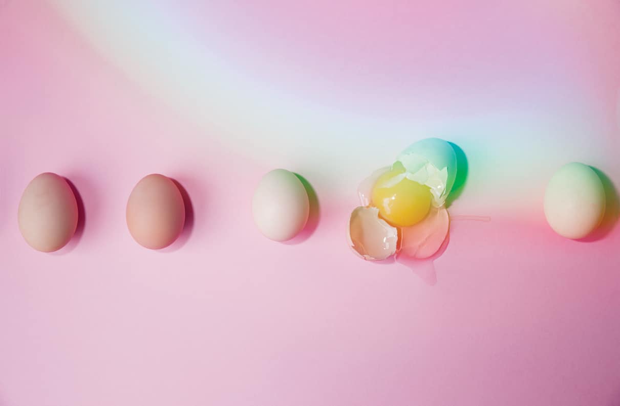 eggs on pink background, one egg is cracked