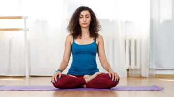5 Things You Need to Know Before You Go on a Meditation Retreat woman in seated meditation in living room