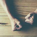 Why Emotional Self-Control Matters person with hands on wooden desk, fists clenched in frustration