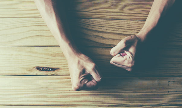 Why Emotional Self-Control Matters person with hands on wooden desk, fists clenched in frustration