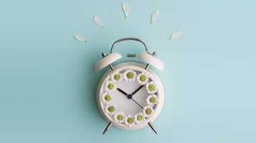 The Mindful FAQ: When to Make a Meditation Session Longer alarm clock with flower petals on top