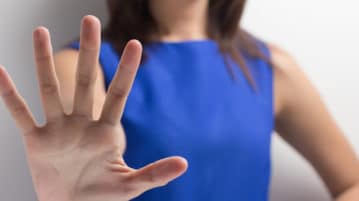 What the Science of Power Can Tell Us about Sexual Harassment woman holding up hand to say "No"