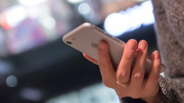 5 Ways to Fight Fake News woman holding iPhone