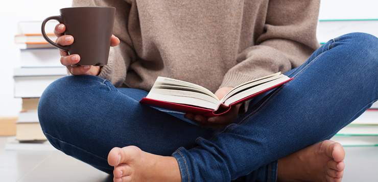 woman sitting cross-legged reading