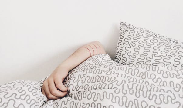Tame Feelings of Shame with this 10-Minute Practice arm laying over blanket, face covered