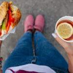 Want to Eat Mindfully? Remember the BASICS woman eating hamburger with drink of tea outdoors