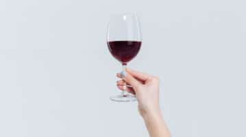 Get More from Your Glass of Wine with this Mindful Drinking Exercise woman holding glass of wine